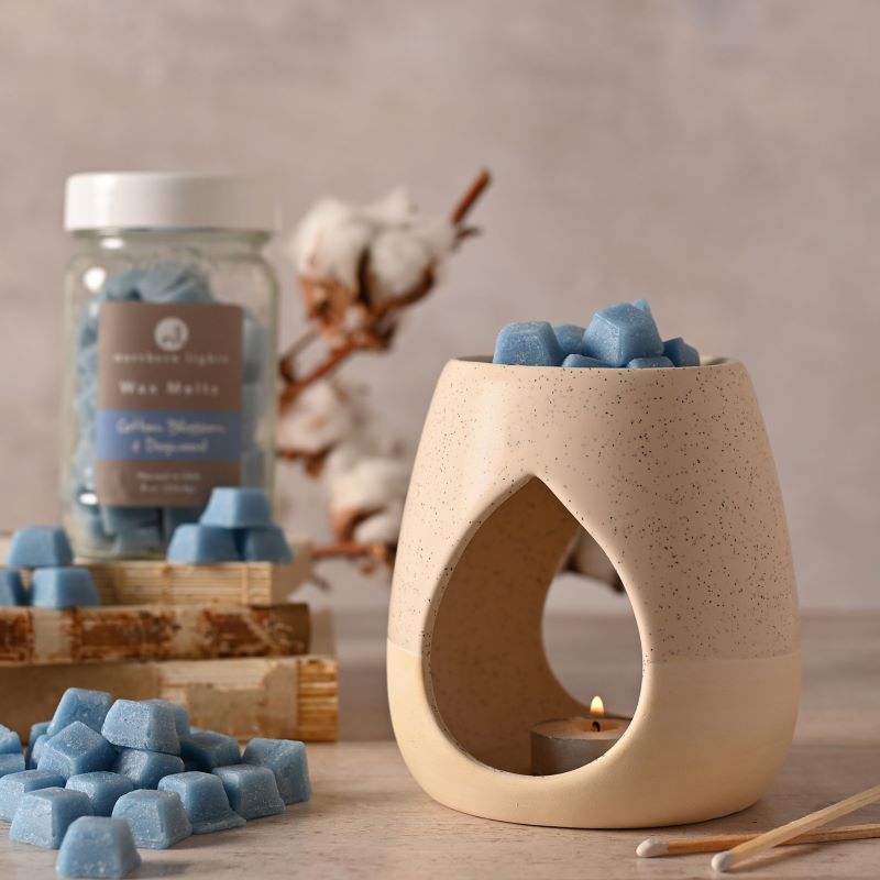 taupe coloured wax melt burner displayed with wax melts in the top and a jar of wax melts beside