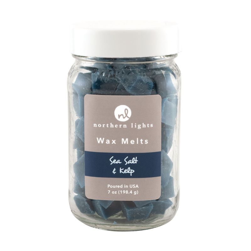 Clear glass jar with white screw on lid containing dark blue wax melts.  The label on front of jar reads northern lights wax melts.  Sea salt and kelp fragrance.  Poured in the USA  7oz