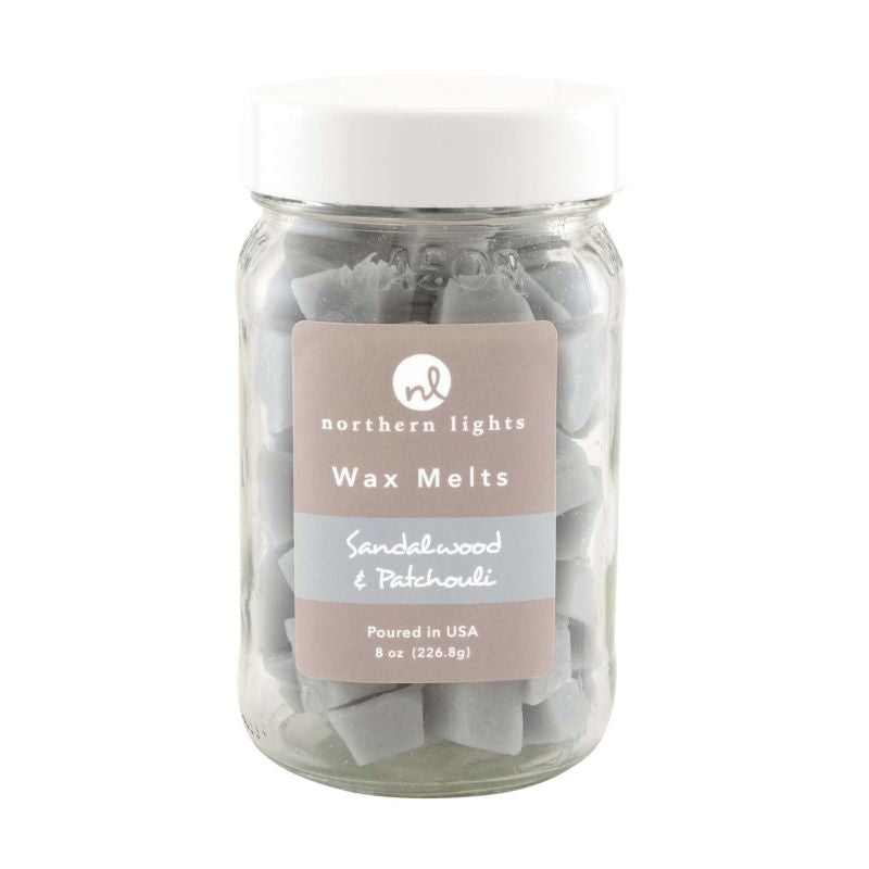 Clear glass jar with white screw on lid filled with grey wax melts.  Label reads northern lights wax melts.  Sandalwood and patchouli fragrance. Poured in the USA  7oz