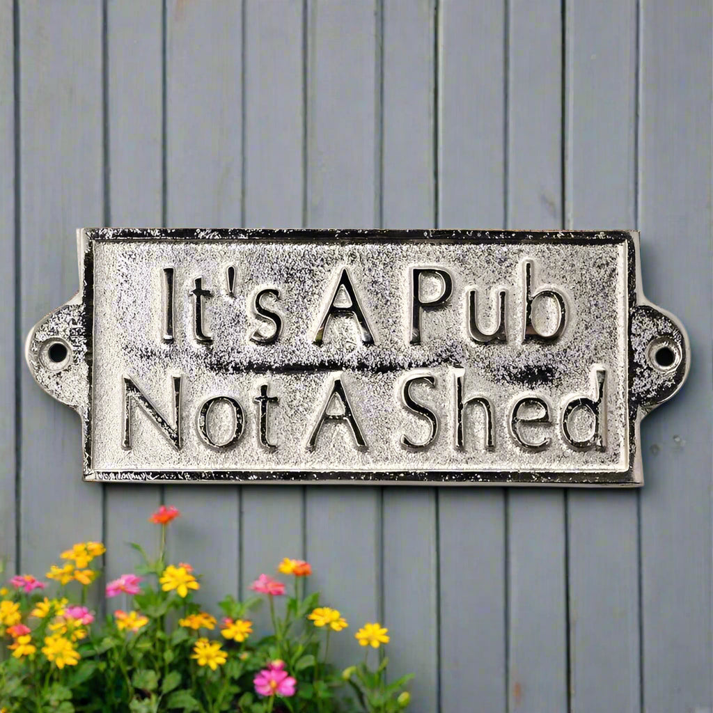 rectangular metal sign with pre-drilled holes at each side.  Embossed words on sign read it's a pub not a shed