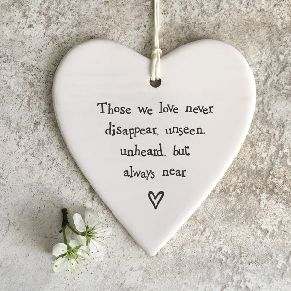 white porcelain heart with twisted paper cord hanging loop.  The words Those we love never disappear, unseen, unheard, but always near are on the front with a little heart underneath