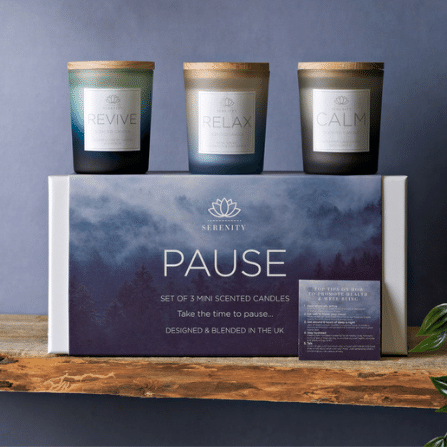set of 3 scented candles presented in a white carboard box with printed sleeve.  The candles are to relax, revive and calm and are in glass votive glasses in blue tones.  Each candle holder has a wooden lid.
